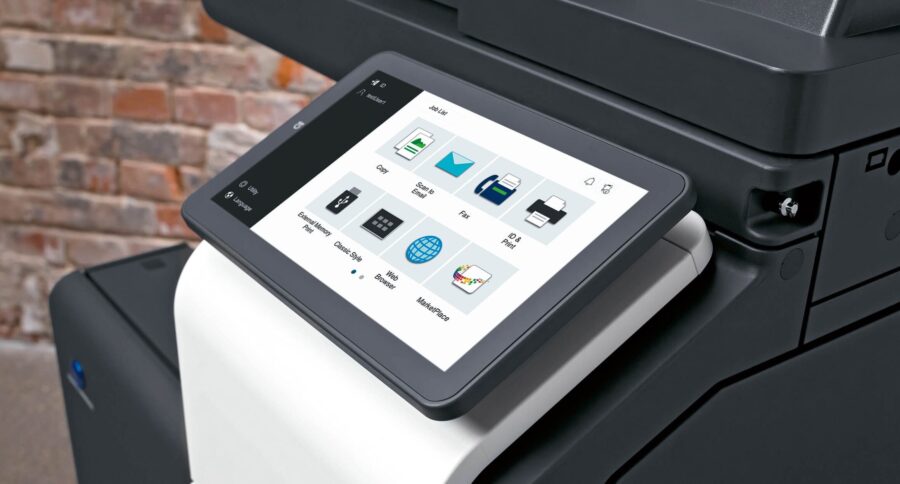 A close-up shot shows the touchscreen interface of a modern multifunction printer, displaying various options like Copy