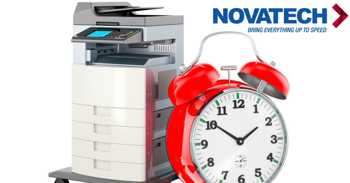 A red alarm clock sits next to a printer, with the 