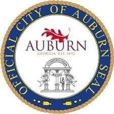 The image is the official seal of the City of Auburn, Georgia, featuring its name, founding year, and a depiction of